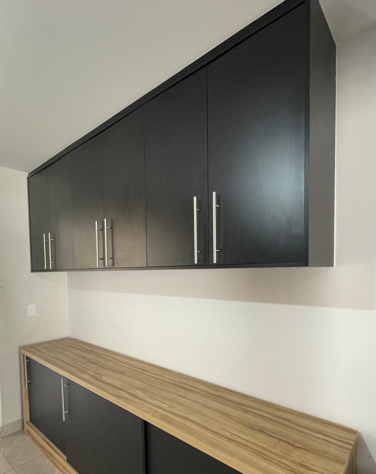 Cozinha preta com bancada amadeirada — Möbius Marcenaria